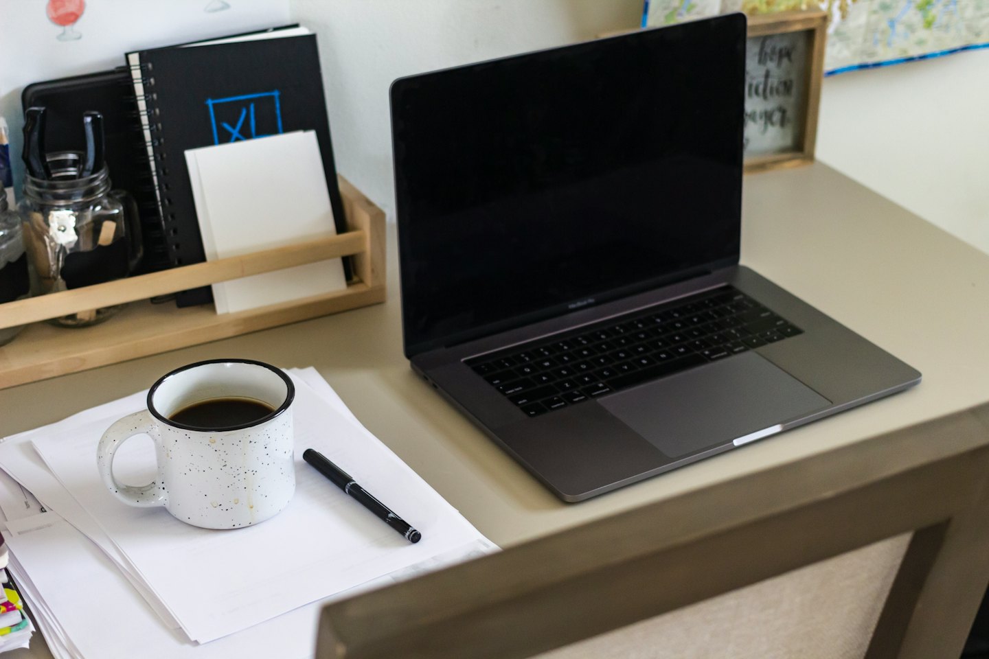 Ein Laptop und ein Schreibtisch-Organizer auf einem aufgeräumten Schreibtisch im Homeoffice.